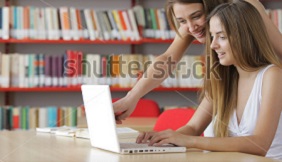 stock-photo-two-young-students-young-women-having-fun-on-laptop-at-library-111509798.jpg